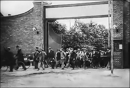 Dělníci opouští bránou areál cihelny v době okolo roku 1924.