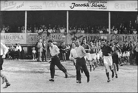 Hráči vbíhají na hřiště U Červených domků, pravděpodobně před rokem 1945.