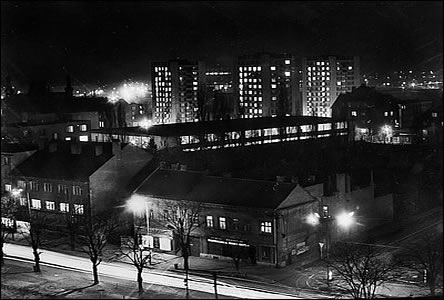 Národní tída u ulice Dukelských hrdin v noci, v pozadí svítí zimní stadion.