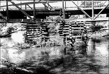 Devné podprné pilíe pod náloí poškozeným mostem u tabák. továrny.